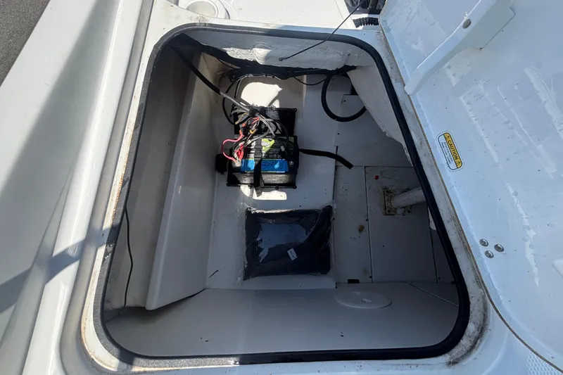 Slide: The Image of 2019 Tahoe 550 TF boat storage compartment with battery and wiring. - 58
