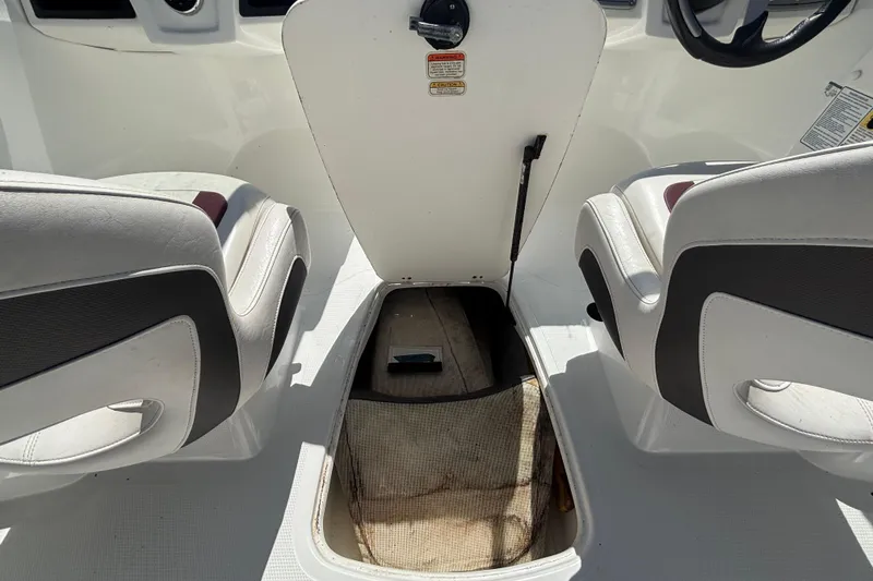 Slide: The Image of 2019 Tahoe 550 TF boat interior with open storage compartment between seats. - 17