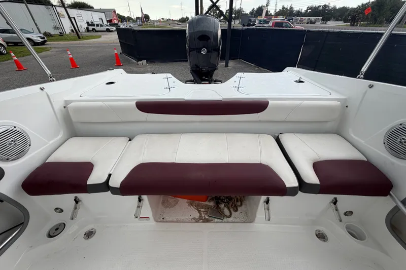 Slide: The Image of 2019 Tahoe 550 TS boat interior with maroon and white seating, outdoor setting. - 51