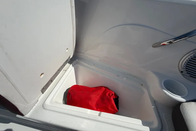 Slide: The Image of Storage compartment in a 2019 Tahoe 550 TS boat with a red bag inside. - 41