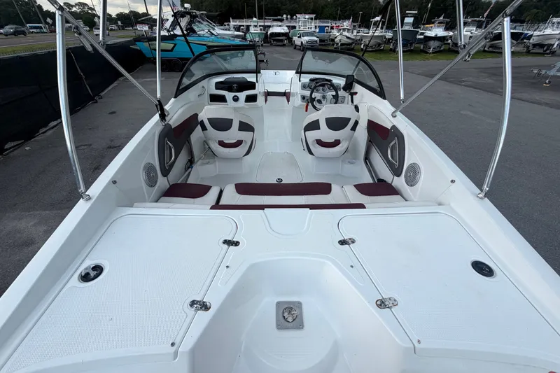 Slide: The Image of 2019 Tahoe 550 TS boat interior with seating and steering wheel, docked at marina. - 12