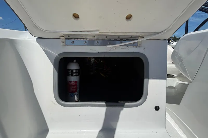 Slide: The Image of Open storage compartment on a 2019 Tahoe 550 TF boat, featuring a fire extinguisher inside. - 42