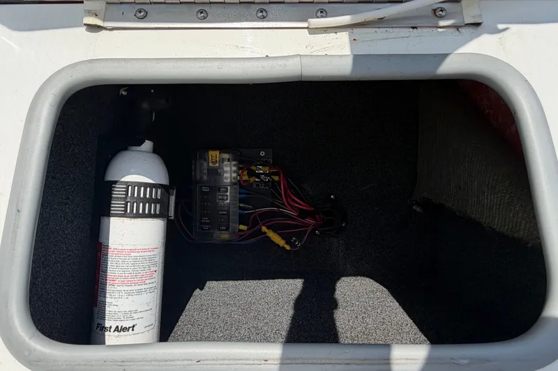 Slide: The Image of A storage compartment with a fire extinguisher and electrical connections inside. - 44