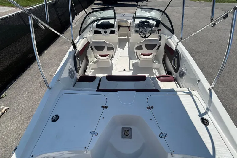 Slide: The Image of 2019 Tahoe 550 TF boat interior with seating and steering wheel, docked on pavement. - 12