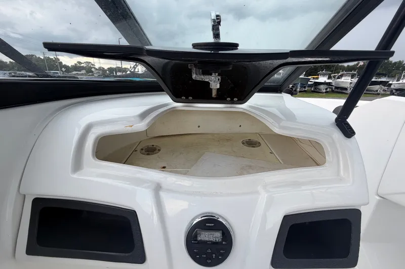 Slide: The Image of 2019 Tahoe 550 TS boat dashboard with storage compartment and audio controls. - 21