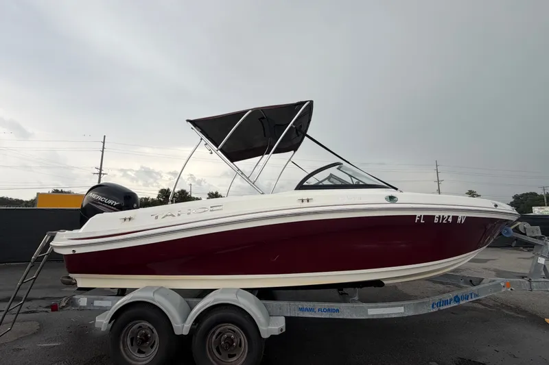 Slide: The Image of 2019 Tahoe 550 TS boat on trailer, featuring a red and white design with a Mercury engine. - 1