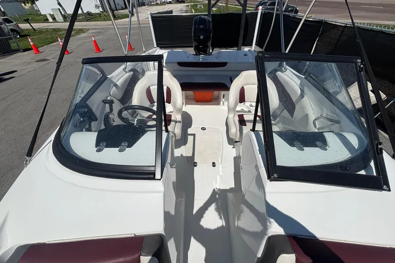 Slide: The Image of 2019 Tahoe 550 TF boat interior with dual seating and steering wheel, parked outdoors. - 45