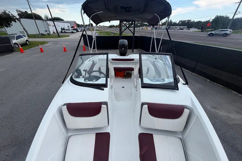 Slide: The Image of 2019 Tahoe 550 TS boat with open cockpit and maroon seating, parked outdoors. - 42