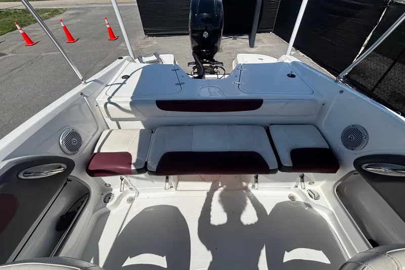 Slide: The Image of 2019 Tahoe 550 TF boat interior with seating and motor, parked near traffic cones. - 49