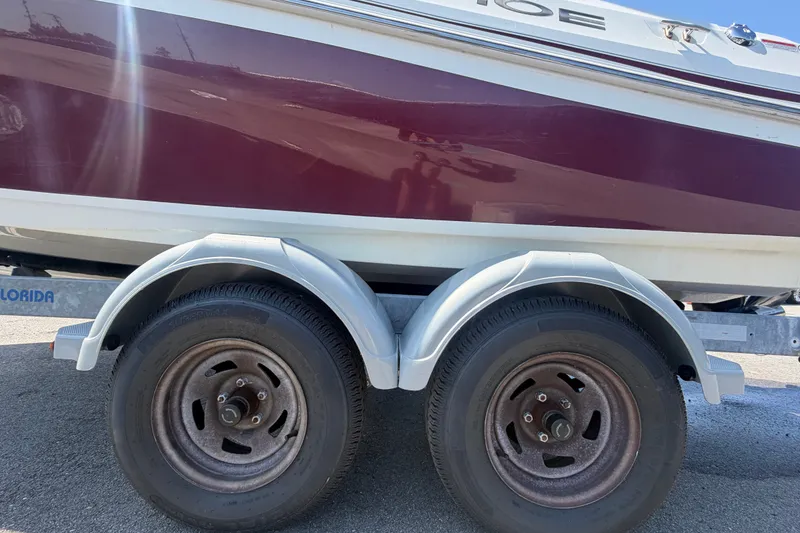 Slide: The Image of 2019 Tahoe 550 TS boat on trailer, featuring dual wheels and maroon hull. - 70