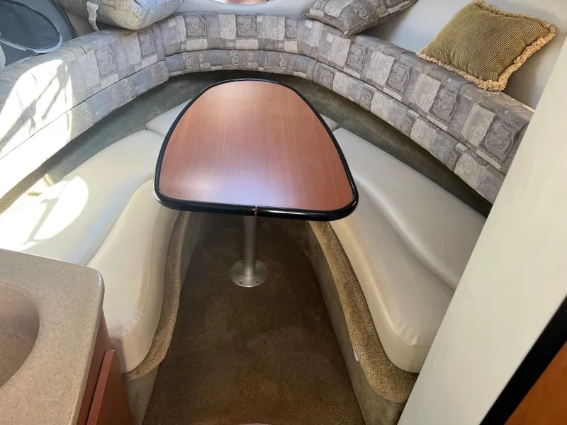 Slide: The Image of 2007 Crownline 250 CR cabin interior with U-shaped seating and wooden table. - 18