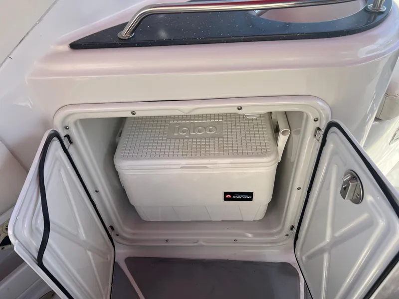 Slide: The Image of 2007 Crownline 250 CR boat with an open storage compartment containing an Igloo cooler. - 24
