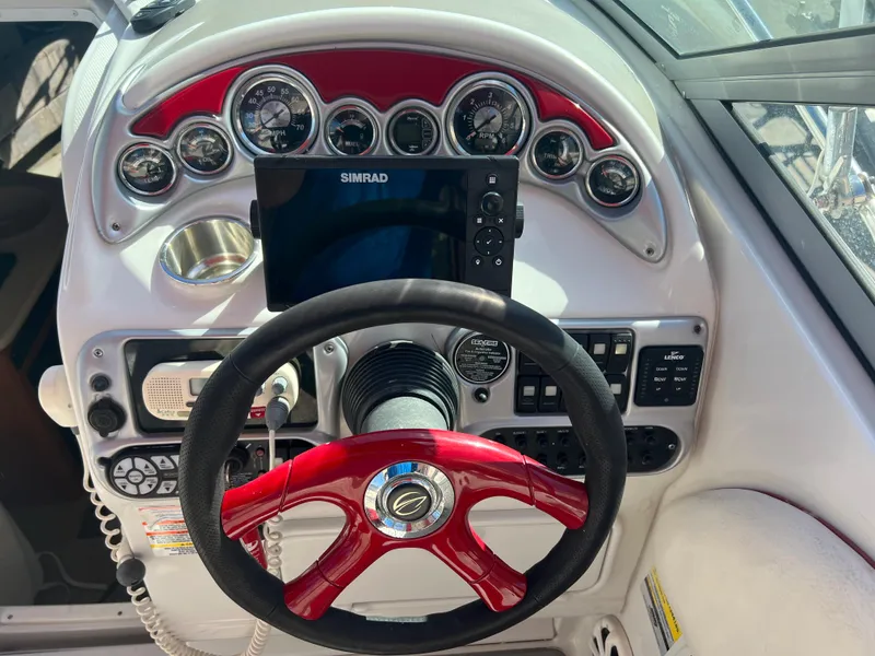 Slide: The Image of 2007 Crownline 250 CR boat dashboard with Simrad display and red steering wheel. - 9