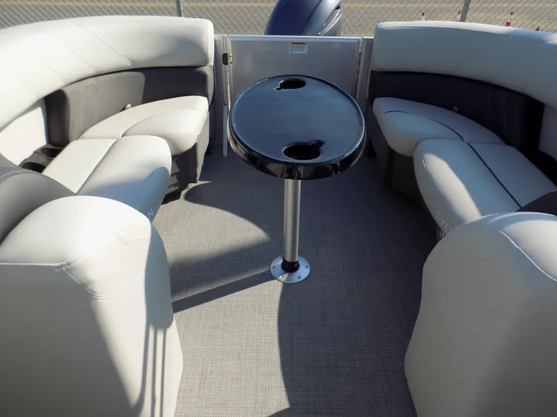 Slide: The Image of 2023 Sylvan Mirage 8522 LZ pontoon boat interior with plush seating and central table. - 11