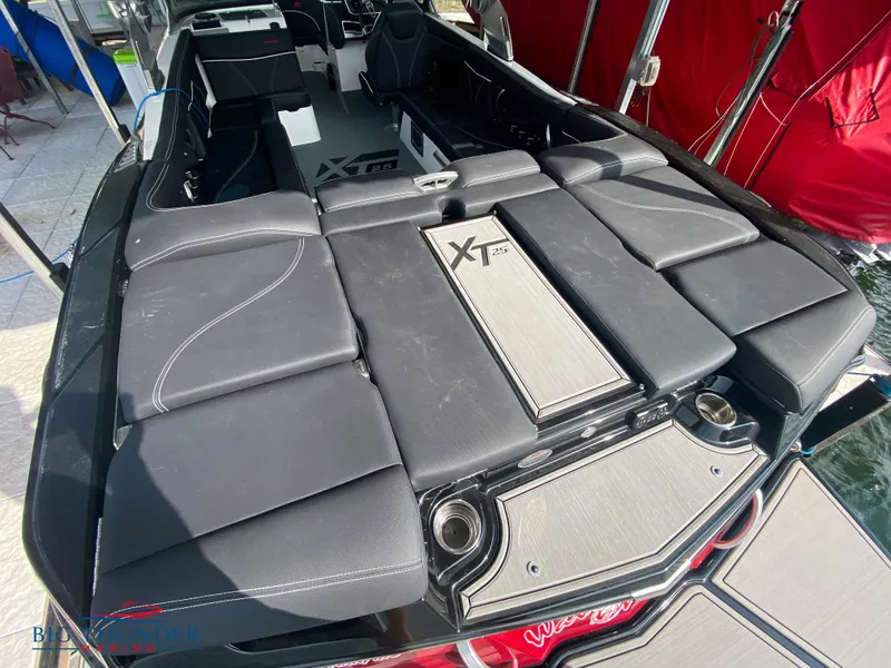 Slide: The Image of 2020 MasterCraft XT25 boat interior with sleek black seating and modern design. - 14
