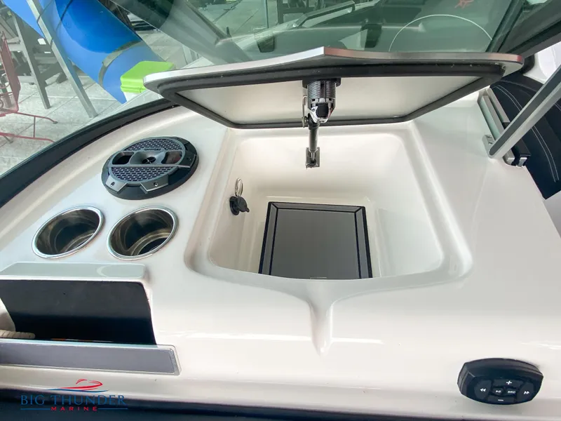 Slide: The Image of 2020 MasterCraft XT25 boat interior with cup holders and storage compartment. - 26