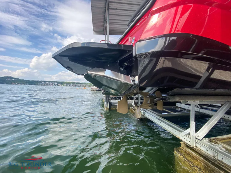 Slide: The Image of 2020 MasterCraft XT25 boat on lift, red hull, docked by lake. - 42