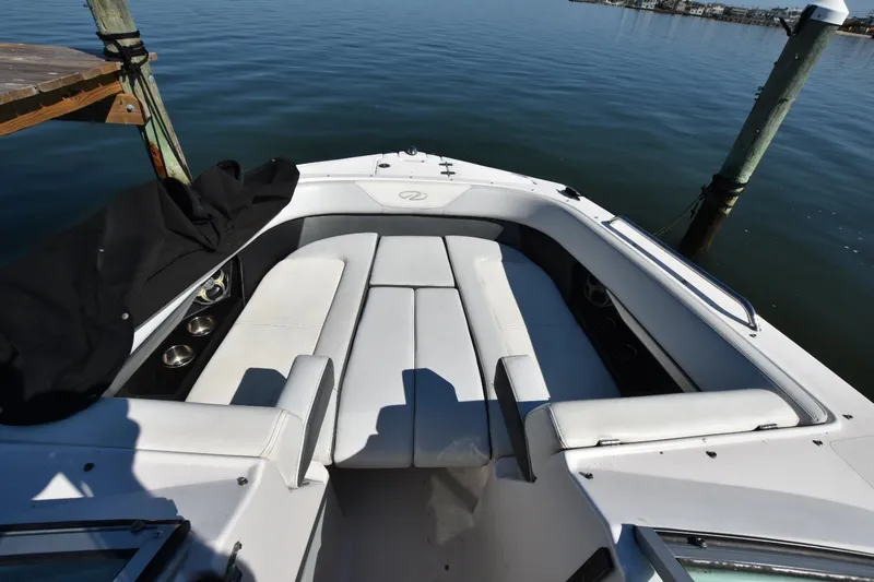 Slide: The Image of 2012 Regal 24 FasDeck boat with white seating, docked on calm water. - 10