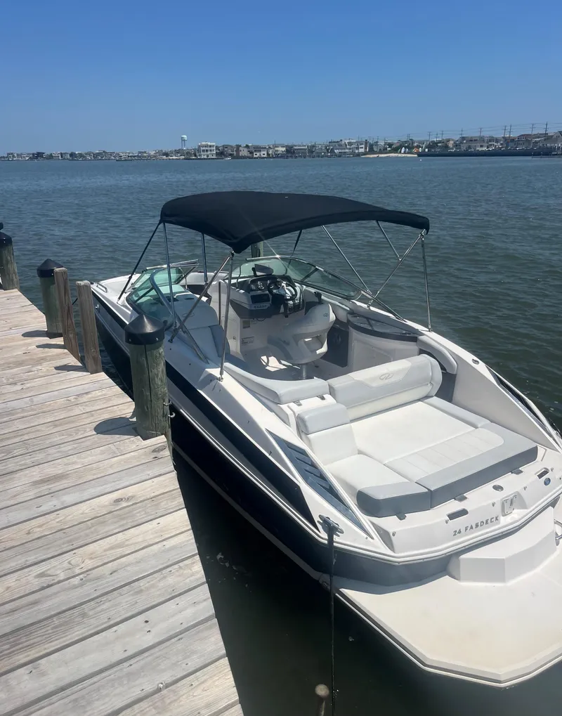 Slide: The Image of 2012 Regal 24 FasDeck boat docked by a wooden pier on a sunny day. - 2
