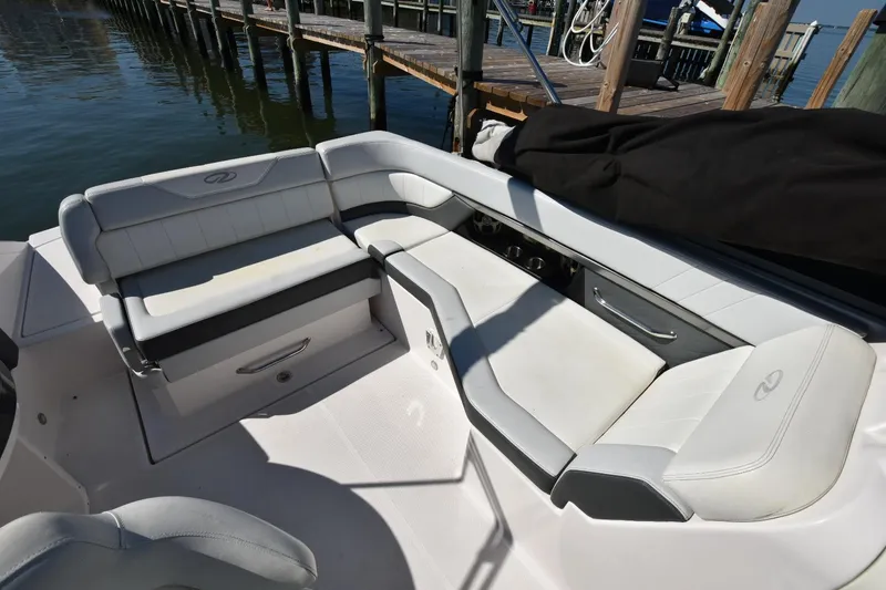 Slide: The Image of 2012 Regal 24 FasDeck boat interior with white seating near a dock. - 9