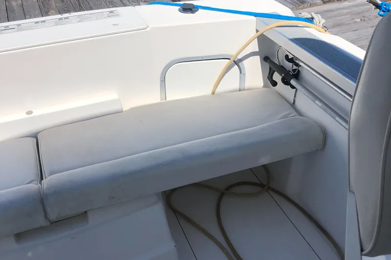 Slide: The Image of 1998 Bayliner 2452 Ciera Express boat interior seating area with white cushions. - 21