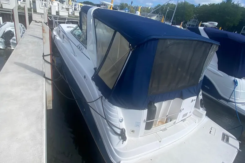 Slide: The Image of 2003 Rinker 342 Fiesta Vee boat docked at a marina with blue canvas cover. - 1