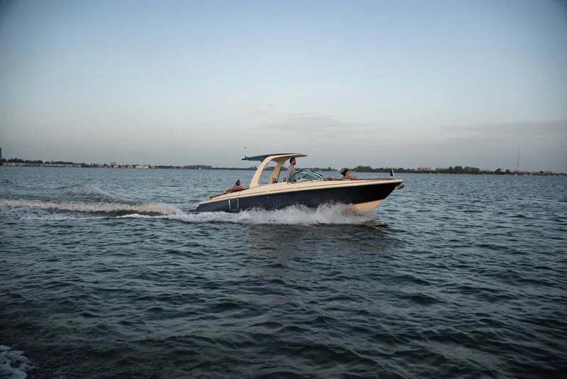 Slide: The Image of 2026 Chris-Craft Launch 28 GT cruising on open water at sunset. - 2