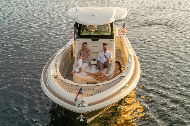 Slide: The Image of 2025 Chris-Craft Catalina 30 boat with people relaxing on deck at sunset. - 2