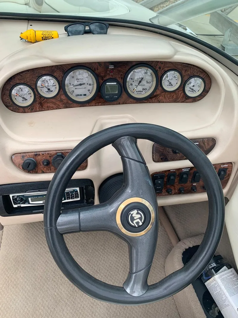 Slide: The Image of Dashboard of a 1999 MasterCraft MariStar 210 boat with wood paneling. - 18