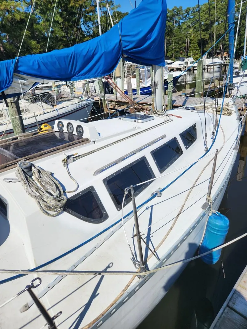 Slide: The Image of 1984 Elite 32 sailboat docked at marina with blue sail cover. - 1