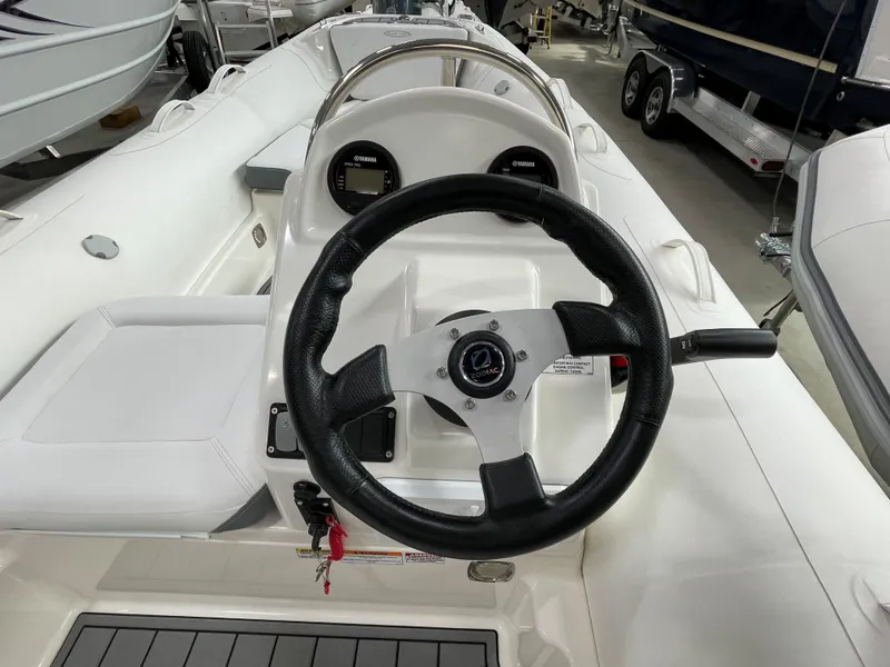 Slide: The Image of 2023 Zodiac Yachtline 490 Deluxe NEO 90hp boat interior with steering wheel and dashboard. - 32