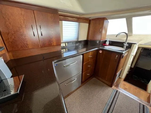 Slide: The Image of Luxurious kitchen area in a 2009 Ovation 52 yacht with modern appliances and wooden cabinetry. - 13