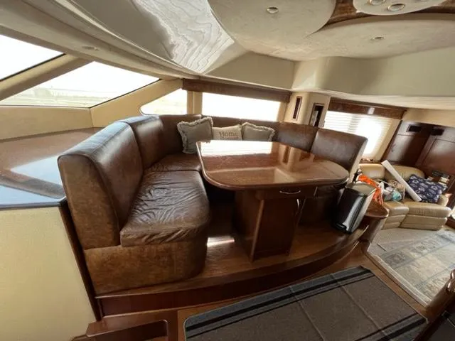 Slide: The Image of Luxurious interior of a 2009 Ovation 52 yacht with leather seating and wooden table. - 16