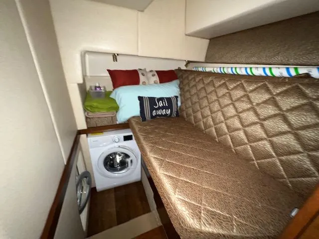 Slide: The Image of Cozy cabin interior of 2009 Ovation 52 with bed, washing machine, and Sail Away pillow. - 20