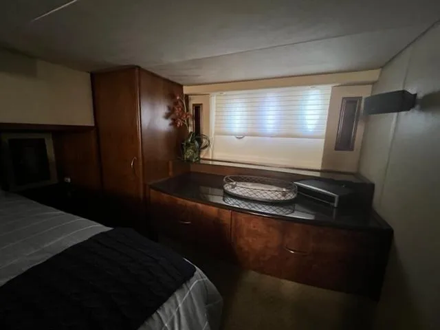 Slide: The Image of Cozy bedroom interior of 2009 Ovation 52 yacht with wooden cabinets and window. - 32