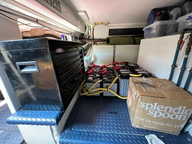 Slide: The Image of Interior of a 2009 Ovation 52 with tool chest, batteries, and storage box. - 49