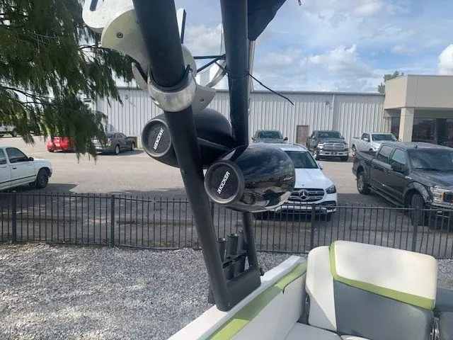 Slide: The Image of 2014 Scarab 215 boat with wakeboard tower speakers in a parking lot. - 13