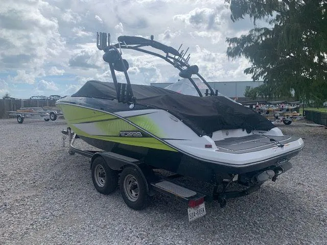 Slide: The Image of 2014 Scarab 215 boat on a trailer, covered and parked outdoors. - 4