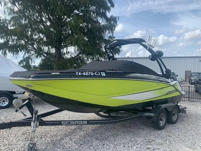 Slide: The Image of 2014 Scarab 215 boat in lime green and black on a trailer. - 5