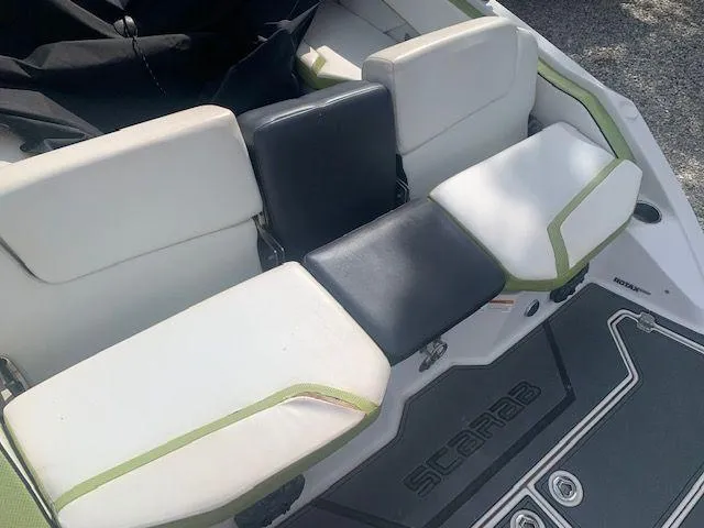 Slide: The Image of 2014 Scarab 215 boat interior seating with white and black cushions. - 6