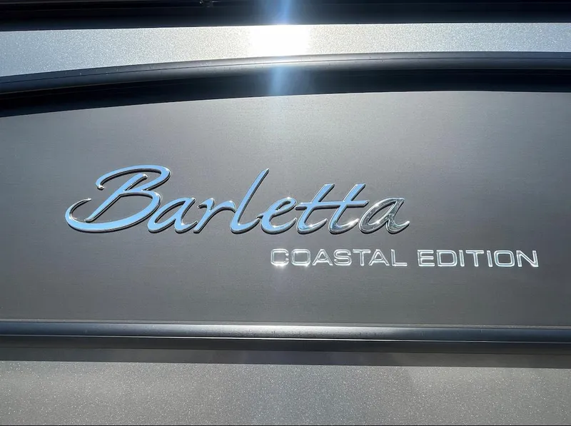 Slide: The Image of 2025 Barletta Lusso 23UC Coastal Edition logo on metallic surface. - 25