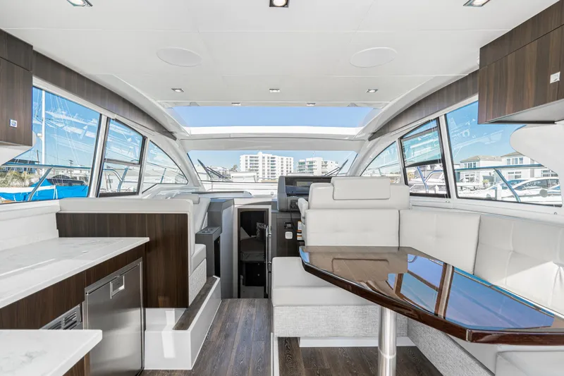 Slide: The Image of Luxurious interior of 2023 Cruisers Yachts 42 Cantius with modern seating and panoramic windows. - 28