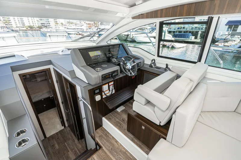 Slide: The Image of 2023 Cruisers Yachts 42 Cantius helm station with modern controls and luxurious seating. - 31