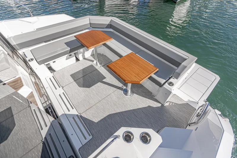 Slide: The Image of 2023 Cruisers Yachts 42 Cantius deck with seating and dual wooden tables. - 17