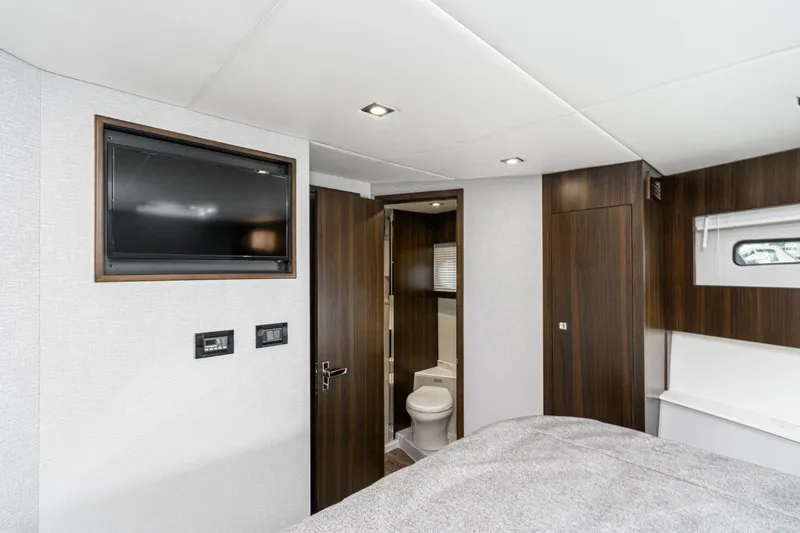 Slide: The Image of 2023 Cruisers Yachts 42 Cantius bedroom with TV, bathroom, and modern wood finishes. - 36