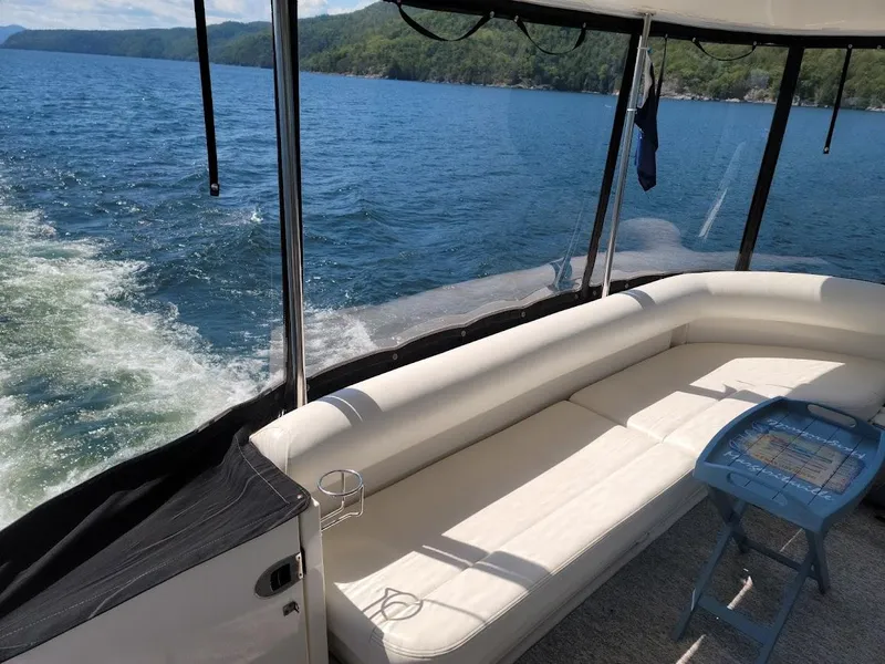 Slide: The Image of 2003 Sea Ray 390 Motor Yacht interior with white seating and scenic lake view. - 10