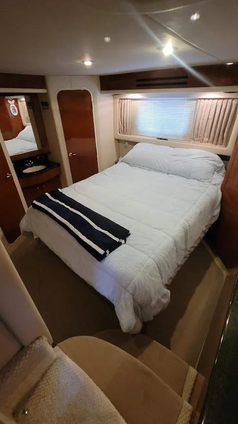 Slide: The Image of 2003 Sea Ray 390 Motor Yacht bedroom with double bed and cozy decor. - 19
