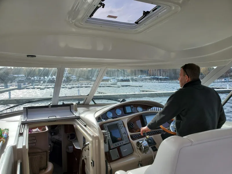 Slide: The Image of Man steering 2003 Sea Ray 390 Motor Yacht on a sunny day. - 2