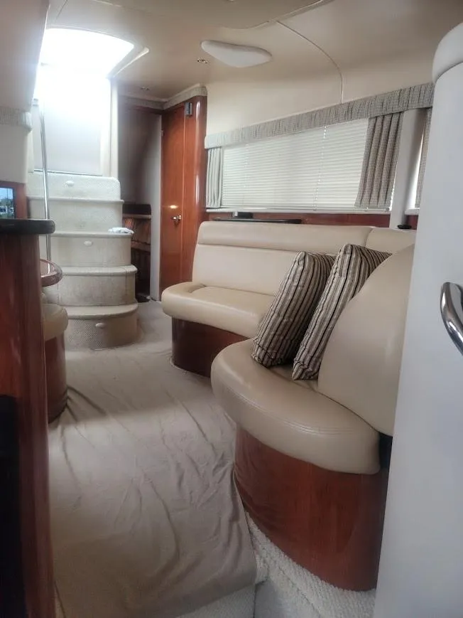 Slide: The Image of Interior of 2003 Sea Ray 390 Motor Yacht with beige seating and striped pillows. - 4