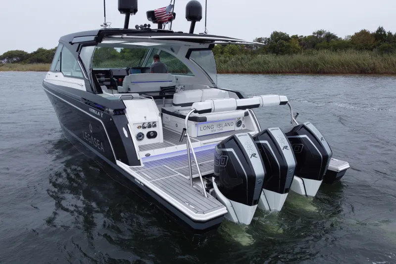 Slide: The Image of 2022 Formula 380 Super Sport Crossover OB boat on water, featuring triple outboard engines. - 13